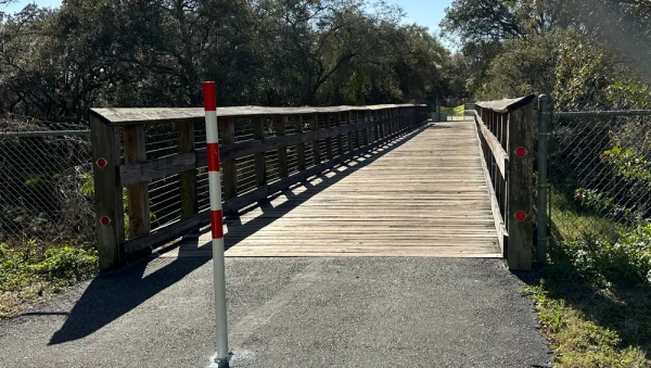 Pole in front of the wooden foot bridge at Rocky Creek in the Upper Tampa Bay Trail