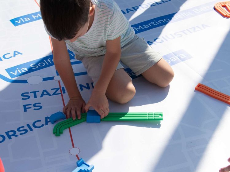 Bambino che gioca su tappetone con percorso tram brescia
