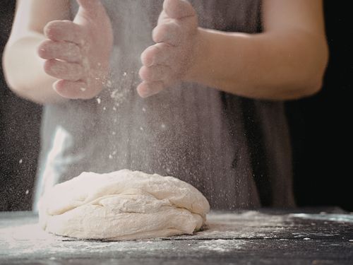 Persona che impasta il pane