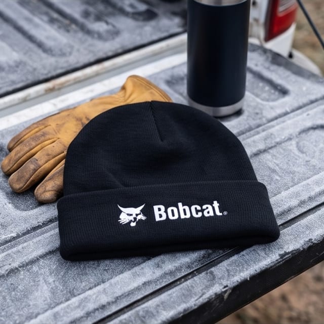 Bobcat beanie on a frosty ute tailgate with work gloves and a thermos