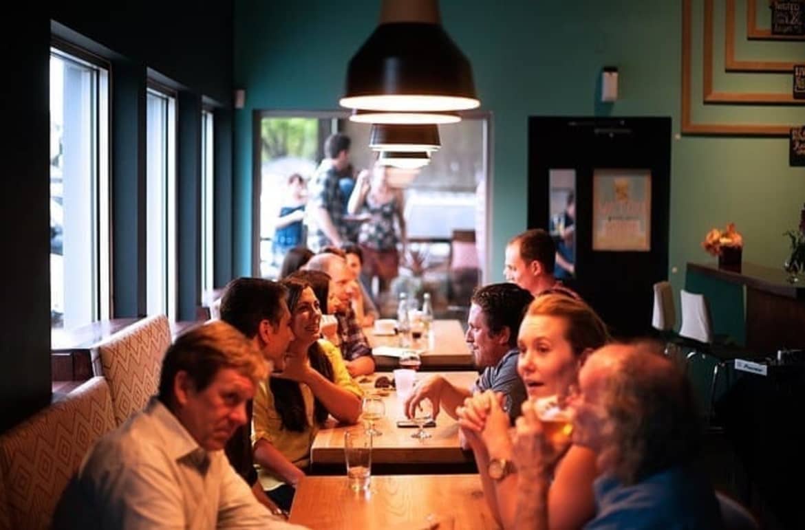 People drink a lot of alcohol or for a lot longer than they mean to. People drinking alcohol in the pub