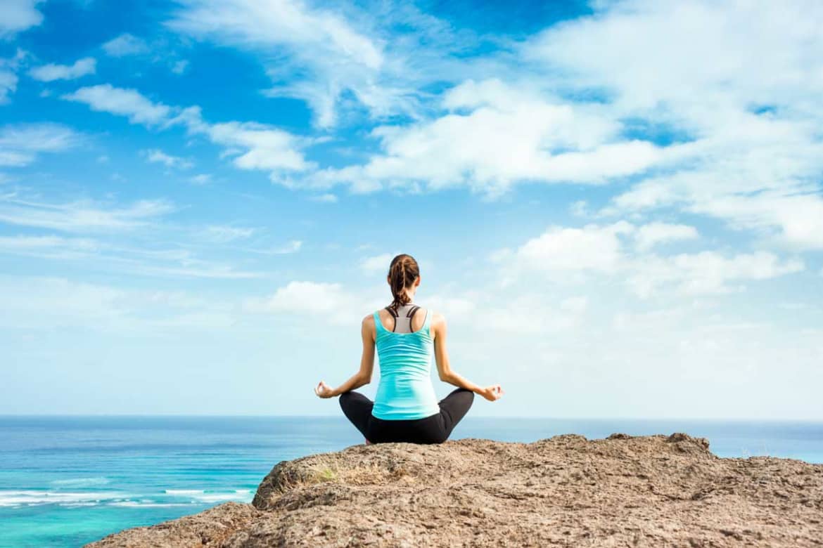 woman meditating on beach - REBT and substance use disorders