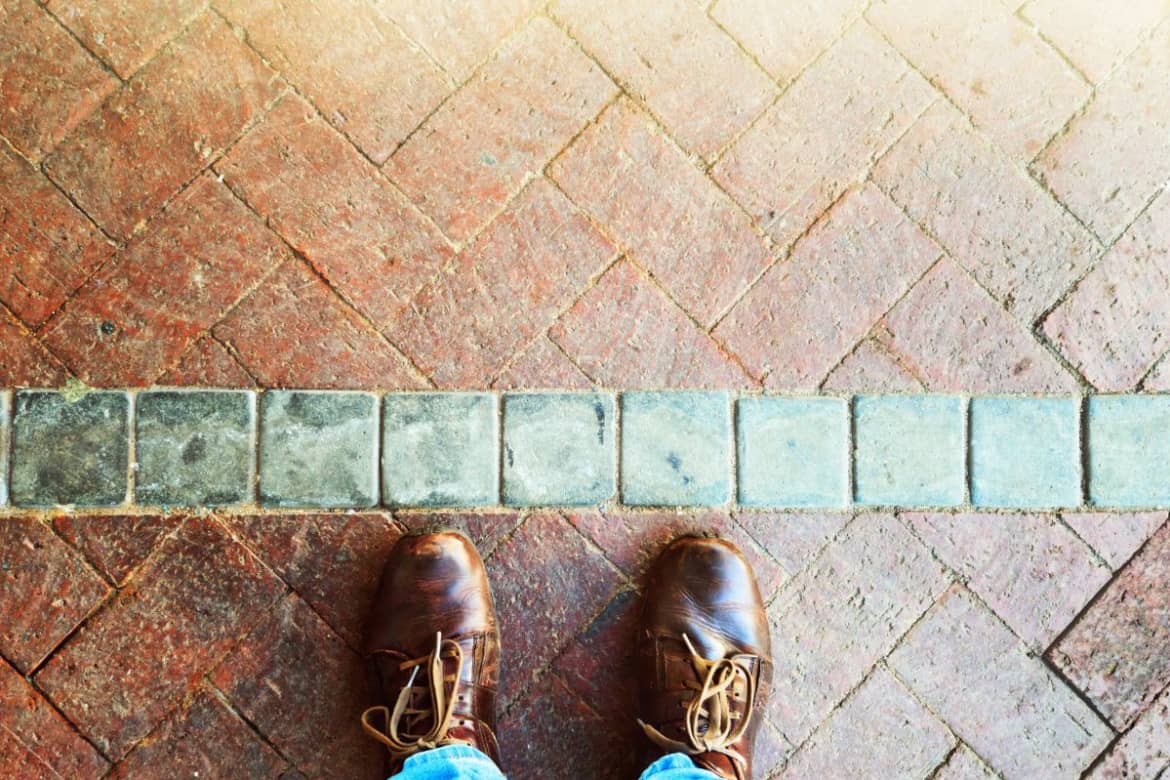 Feet standing at a line on a path, symbolizing the first step and setting boundaries in recovery.