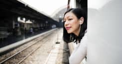 Asian woman leaning out of the window on a train