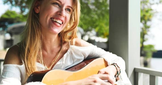 Woman Smiling Laying Guitar