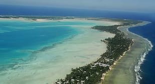 Aerial photo of an oceanian island. Photo by Government of Kiribati from Wikimedia Commons.