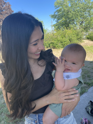 Person smiling with their recently born baby