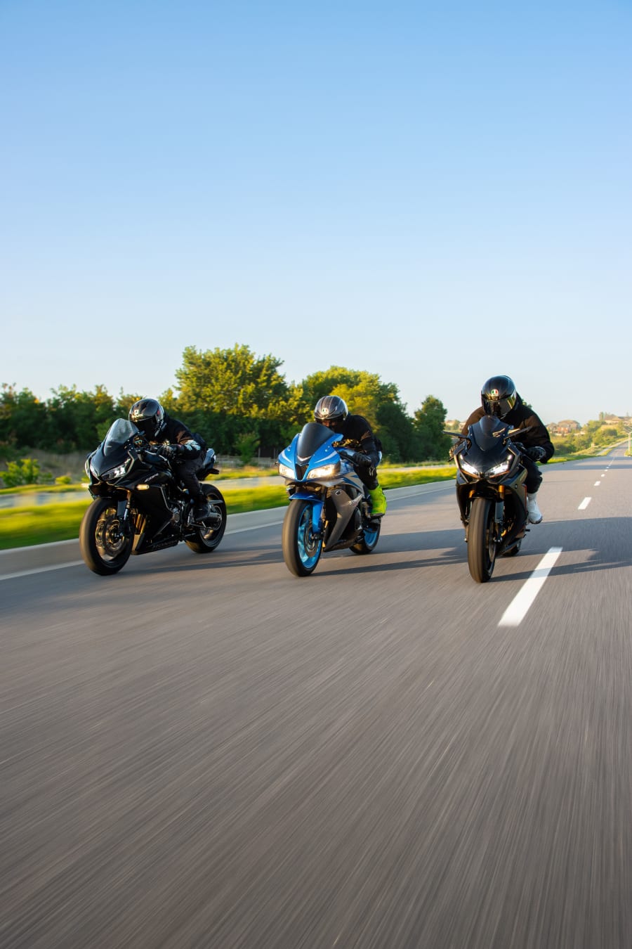 Tres moteros rodando juntos por carretera