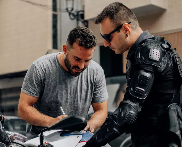 Dos moteros revisando juntos los papeles del alquiler