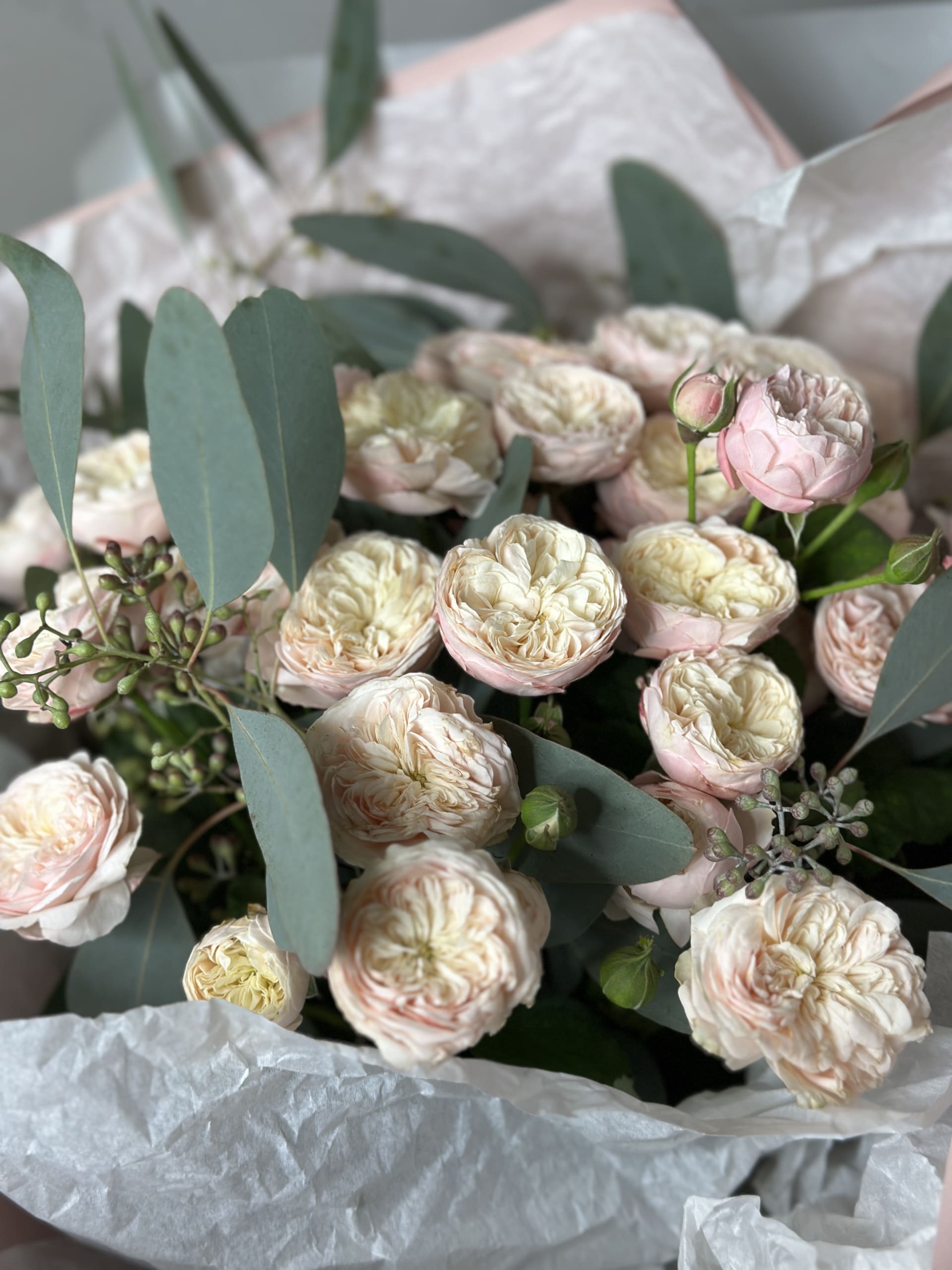 Bouquet of pastel peonies wrapped in paper