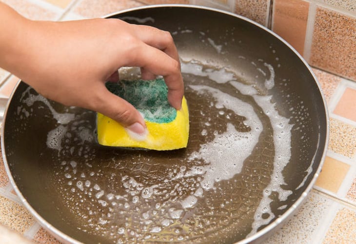Vệ sinh chảo chống dính bị cháy khét tại nhà bằng nước rửa chén và miếng bọt biển mềm