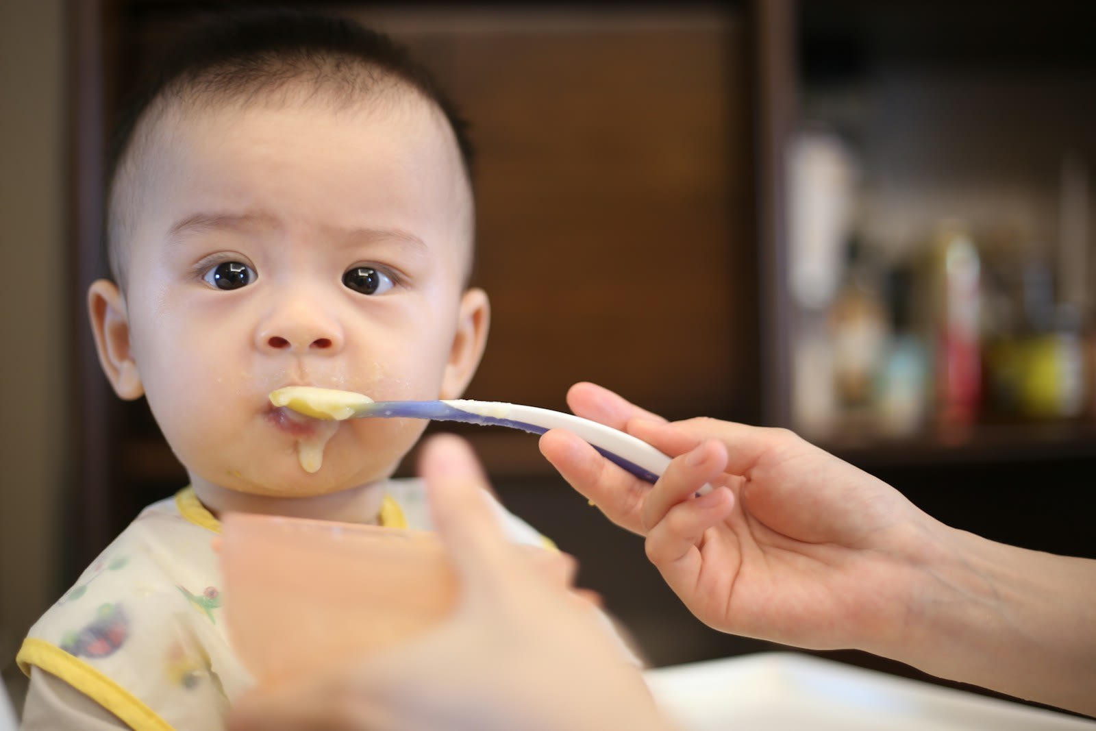 Bé được mẹ đút thìa bột trong bữa ăn dặm