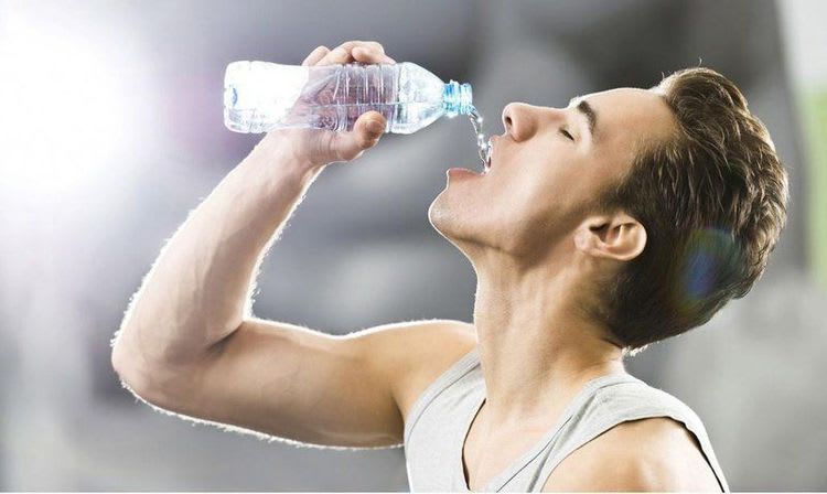Người tập uống nước để tránh mất nước khi vận động cường độ cao