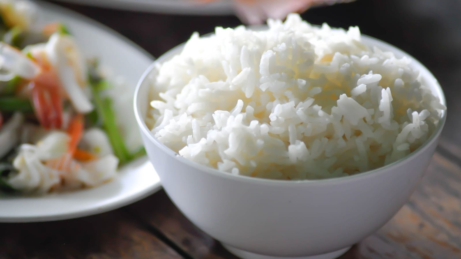 Bát cơm trắng đặt cạnh rau và thịt trong bữa ăn giảm cân