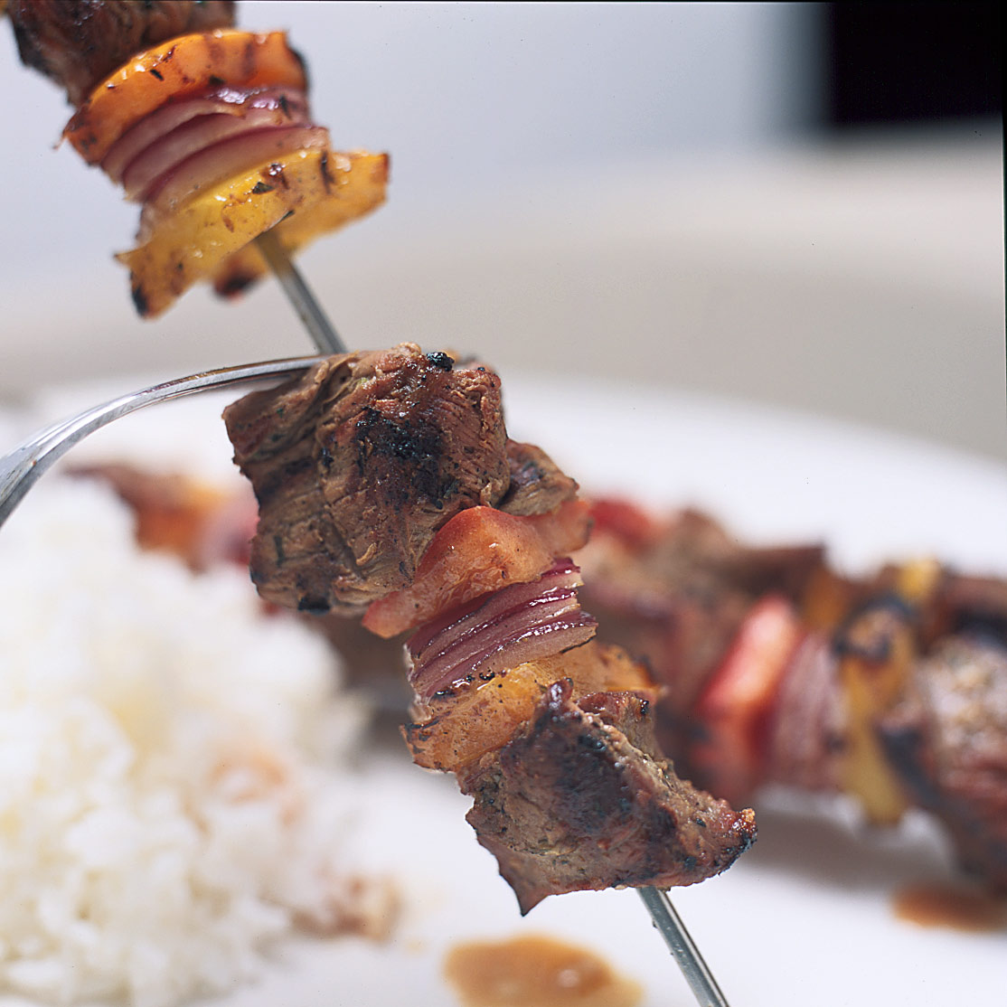 Grilling marinated shashlik on a grill. Shashlik is a form of Shish kebab  popular in Eastern, Central Europe and other places. Shashlyk (meaning  skewered meat) was originally made of lamb. Stock Photo