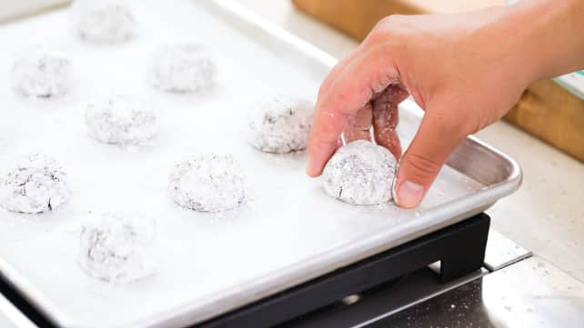 Spacing dough balls evenly on rimmed baking sheet.