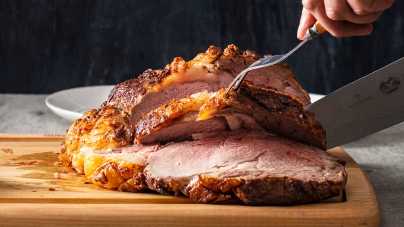 Chef de-boning and carving a portion of barbecued prime rib steak