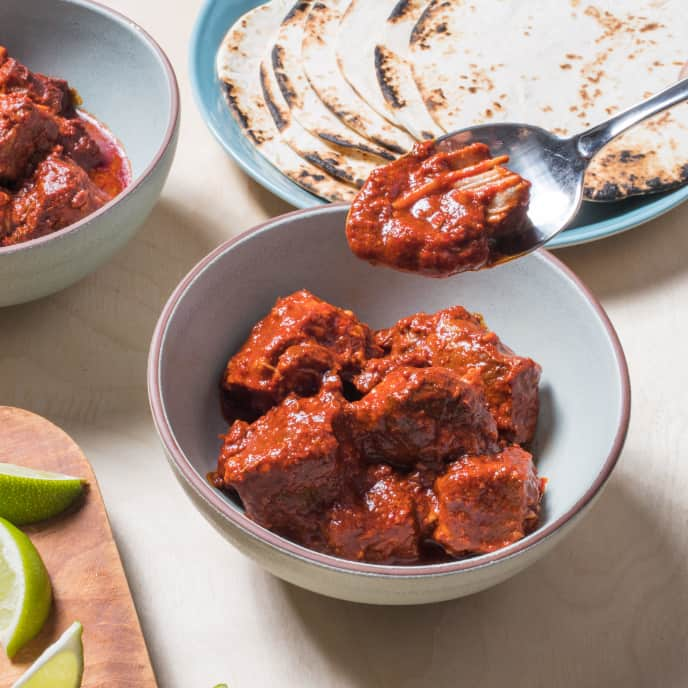 Pork cubes in red chile sauce, braised and served with rice and beans.