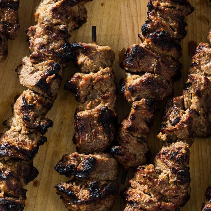 Grilling marinated shashlik on a grill. Shashlik is a form of Shish kebab  popular in Eastern, Central Europe and other places. Shashlyk (meaning  skewered meat) was originally made of lamb. Stock Photo