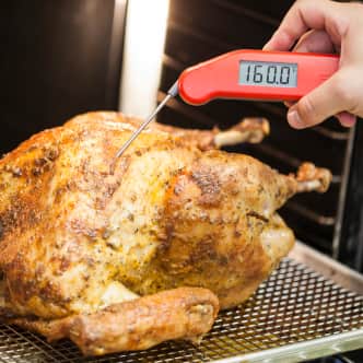Checking the temperature of breast meat on a turkey so it reads 160 degrees F