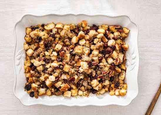 Bread Stuffing with sausage, dried cherries, and pecans in a white serving dish