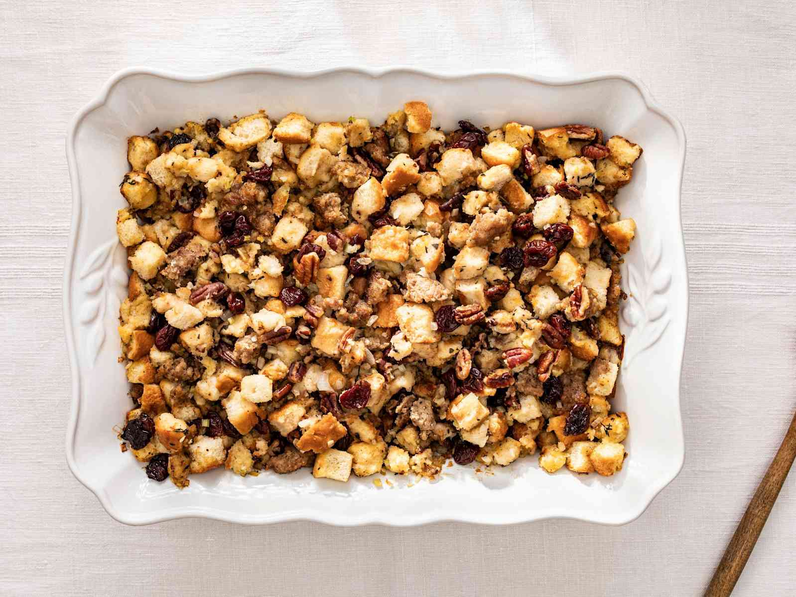Bread Stuffing with sausage, dried cherries, and pecans in a white serving dish