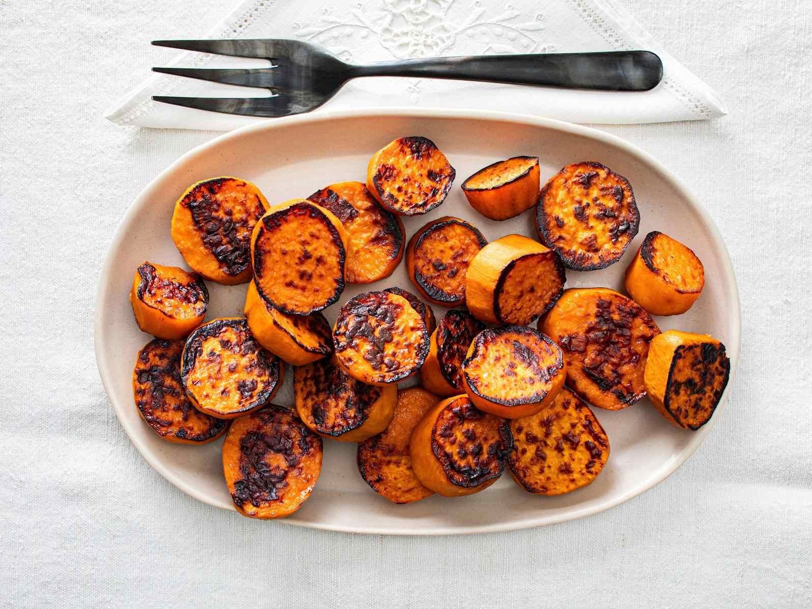 Browned, roasted sweet potatoes on serving platter
