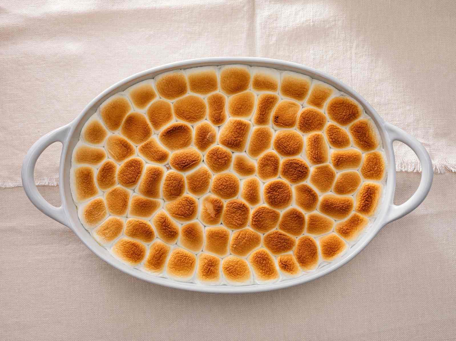 Sweet potato casserole with a marshmallow topping in a serving dish