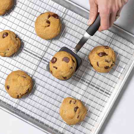A tester uses a compact spatula to maneuver small cookies.