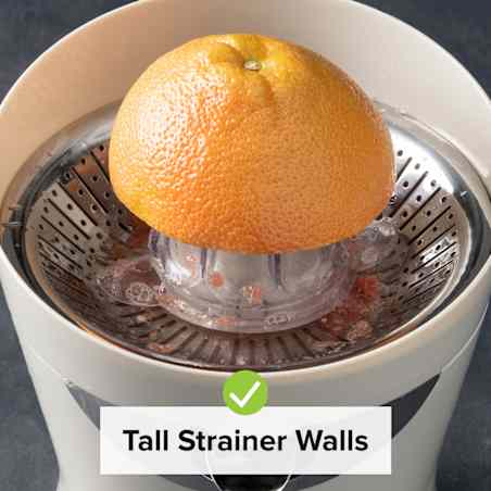 A grapefruit half is positioned on a juicing cone with its flesh side down in a white electric juicer. 