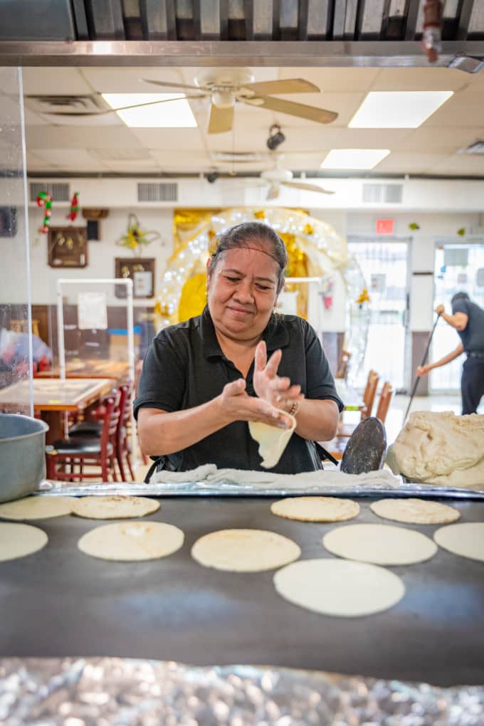 Santa Roman makes tortillas on a griddle at El Hidalguense, a restaurant in Houston, Texas specializing in barbacoa.
