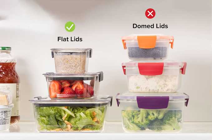 Two stacks of food containers filled with salad, fruits, steamed vegetables, and rice.
