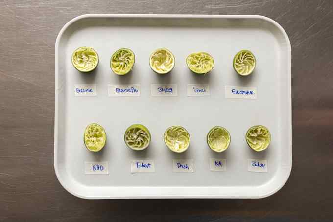 Ten lime halves are laid across a white tray.