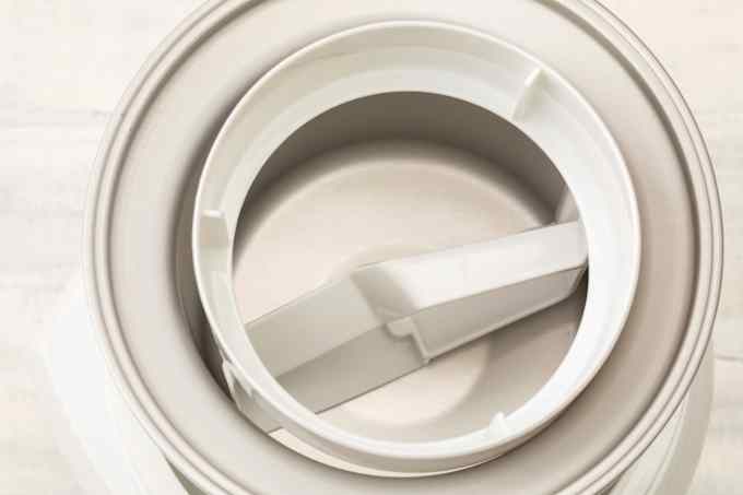 Interior and churning paddle of white ice cream maker.