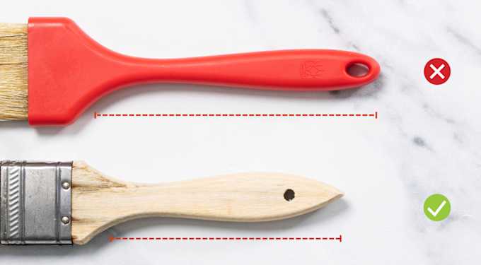 One pastry brush with a long red handle and one pastry brush with a medium-length wood handle.