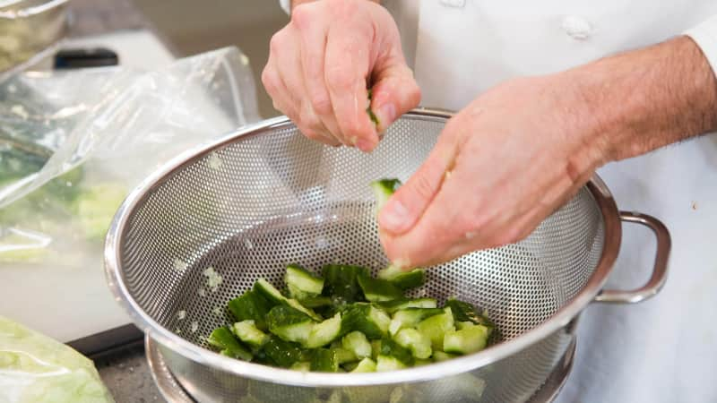 Tearing smashed cucumbers into smaller chunks.