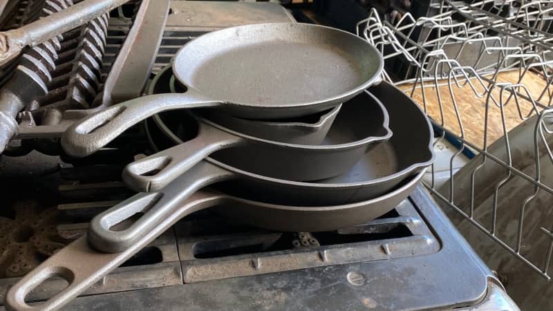 stack of antique cast iron skillets