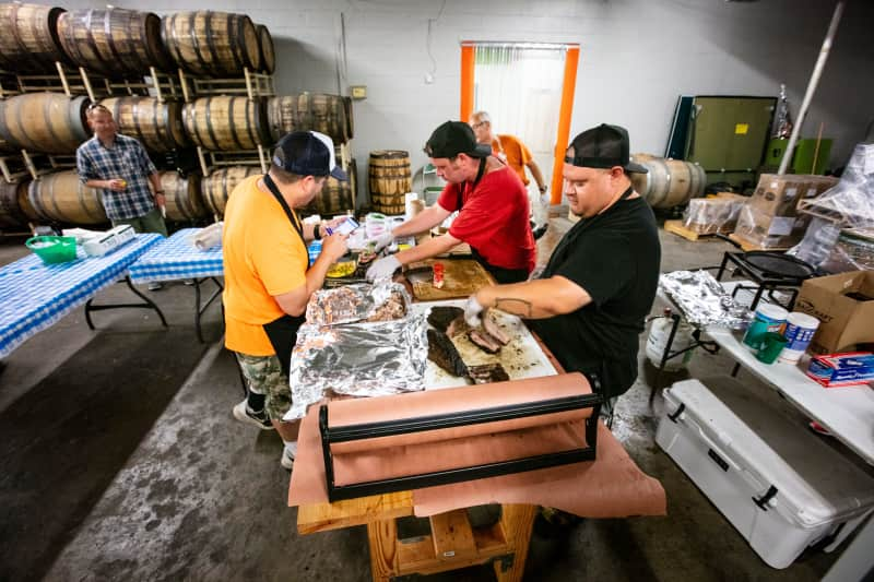 three men slicing and preparing barbecue