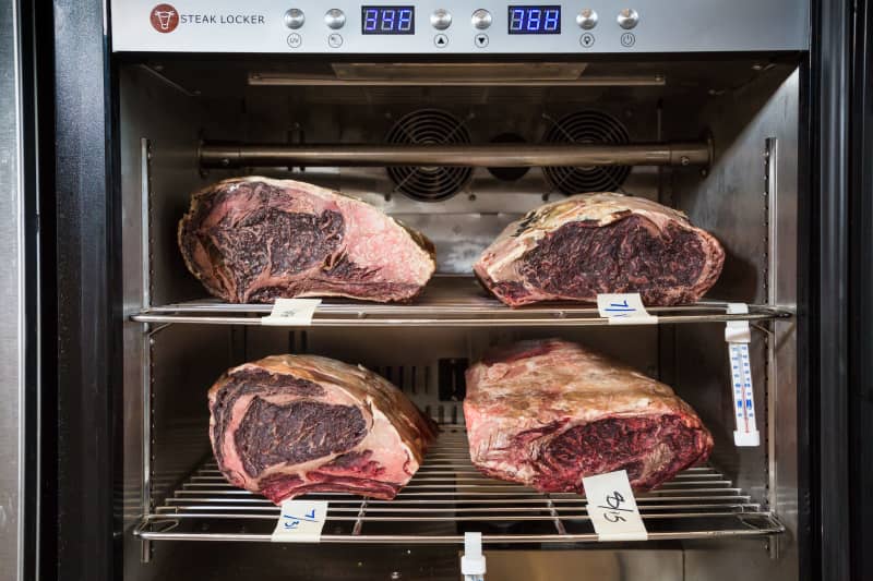 Shot inside our dry-aging refrigerator showing our four different prime-grade aged rib eyes. 