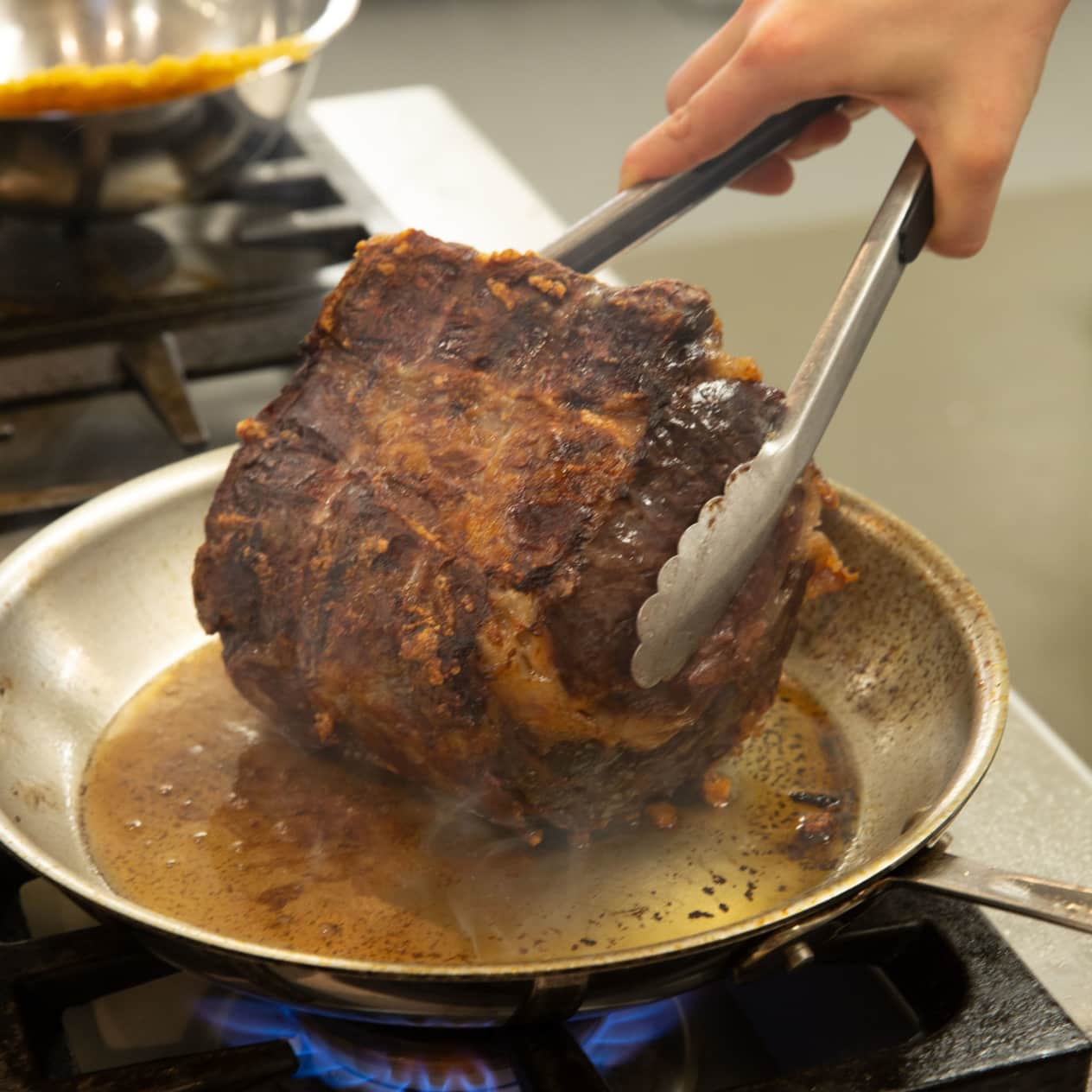 Chef de-boning and carving a portion of barbecued prime rib steak