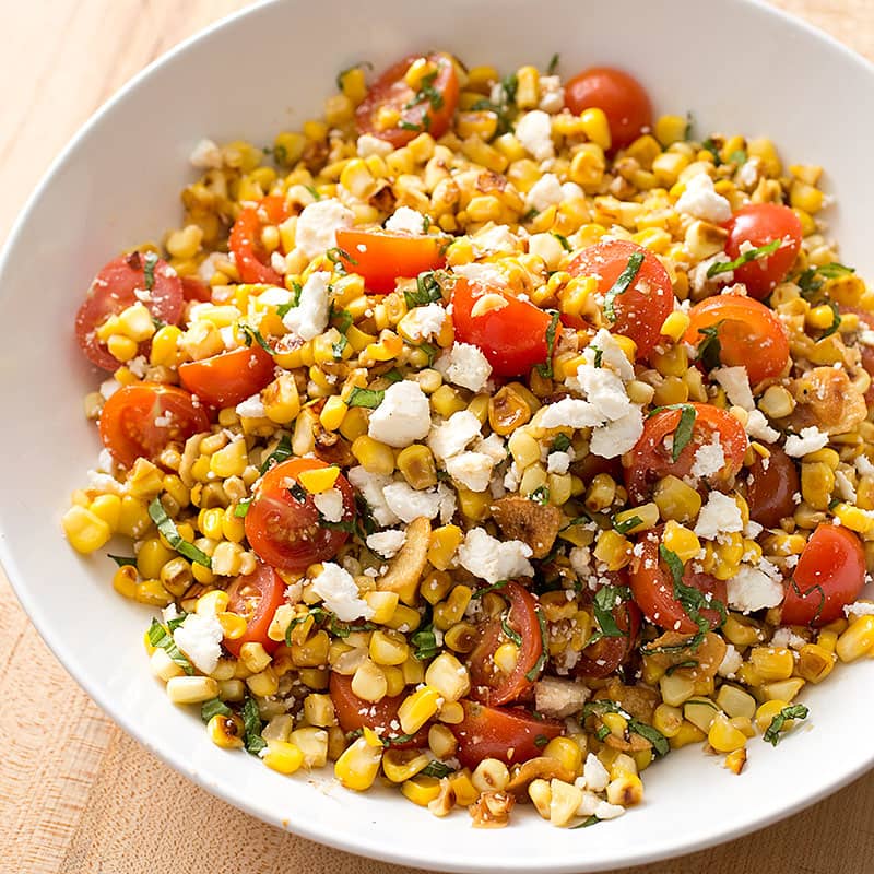Sautéed Corn with Cherry Tomatoes, Ricotta Salata, and Basil | America's Test Kitchen