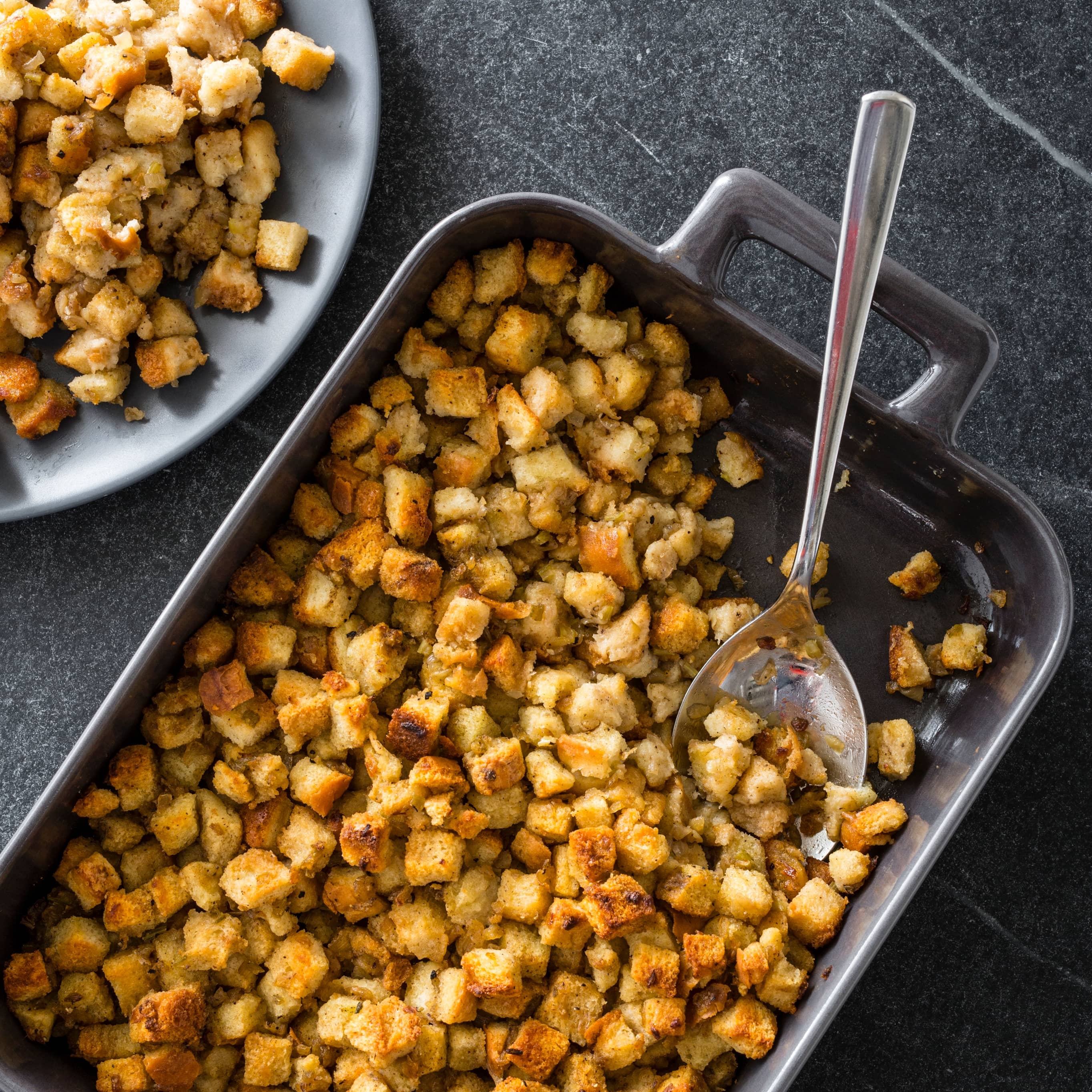 Stuffing in a roasting pan with serving spoon