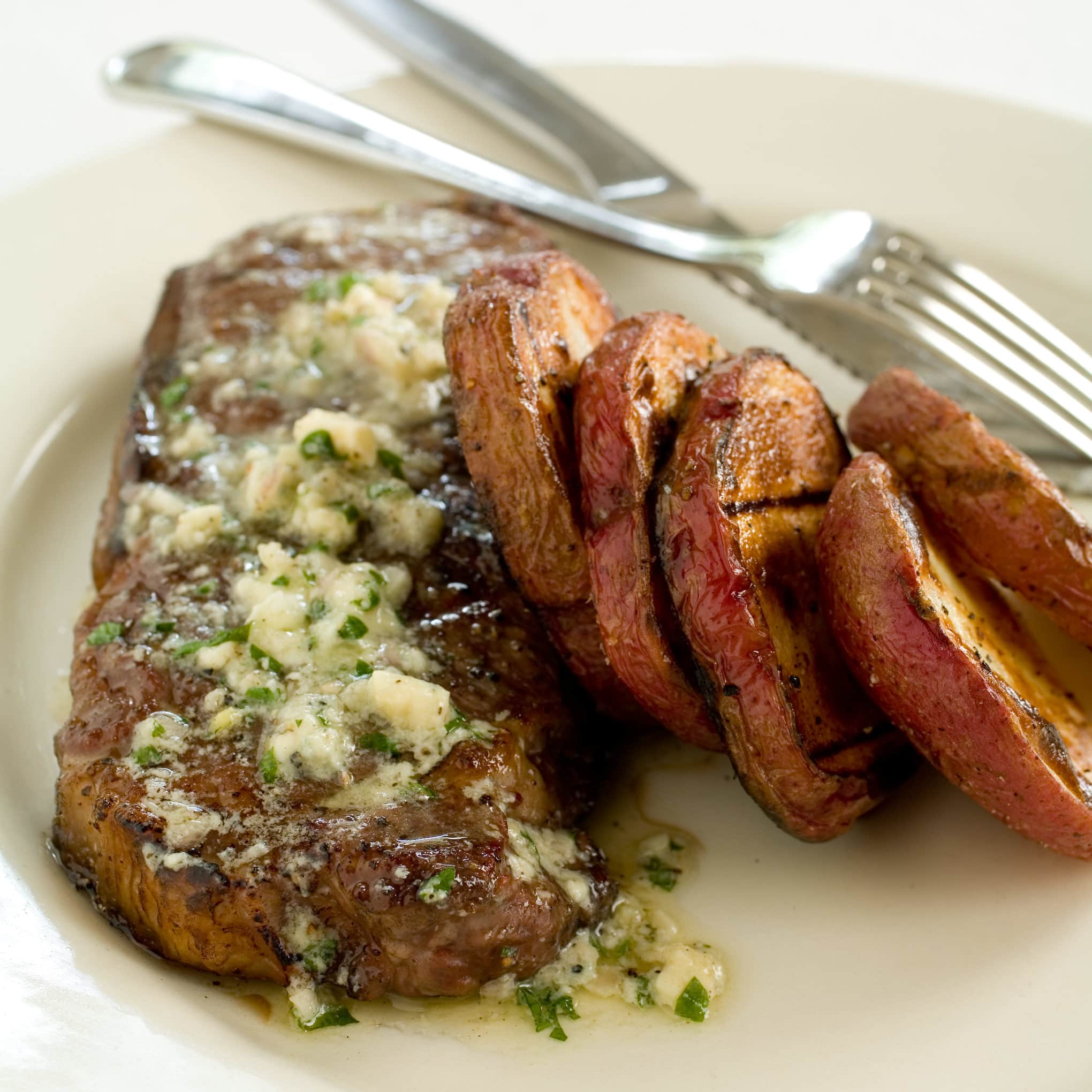 Gas-Grilled Strip Steaks and Potatoes with Blue Cheese Butter