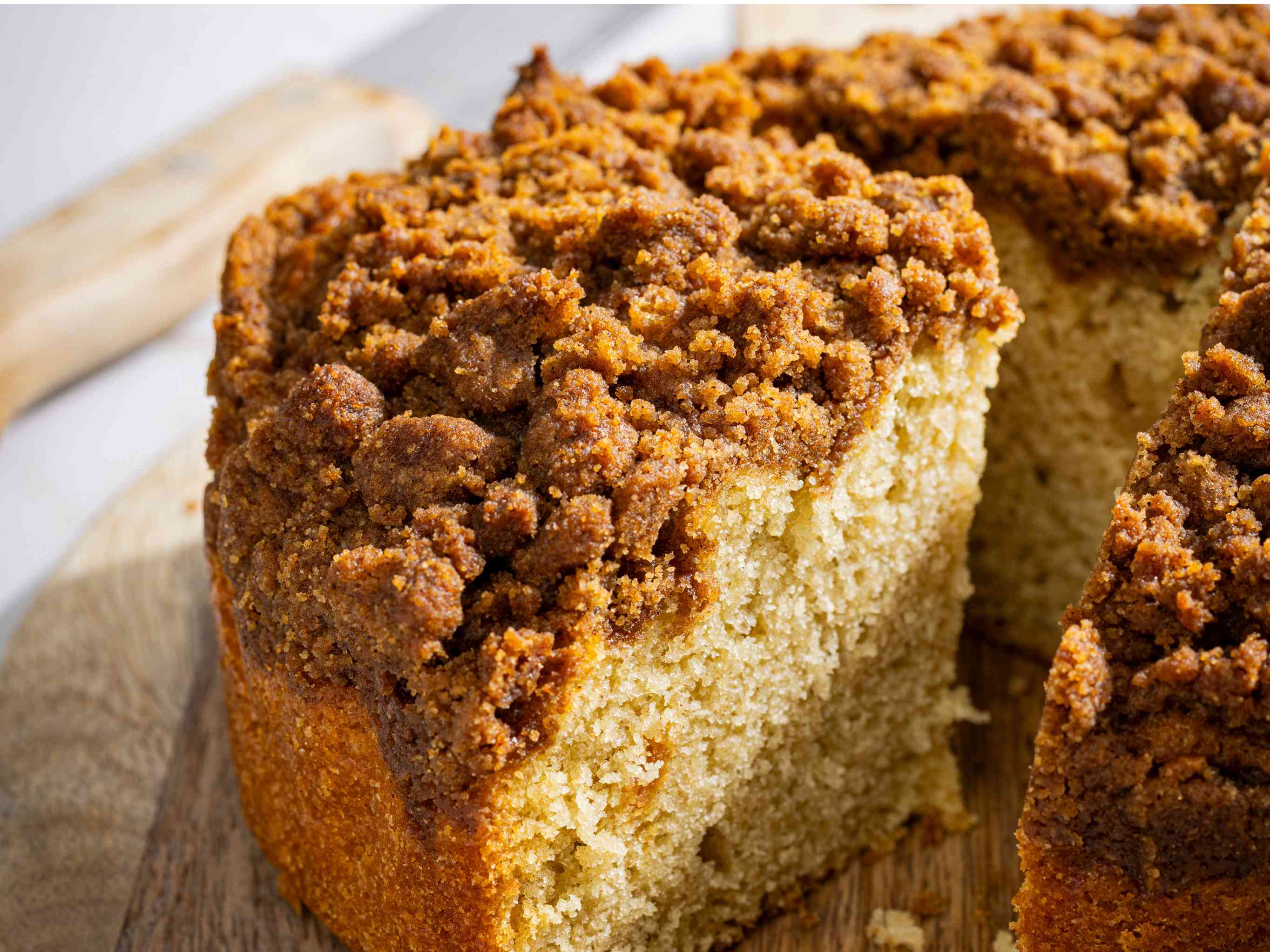 Slice of cinnamon streusel coffee cake angled so you can see the tender interior.