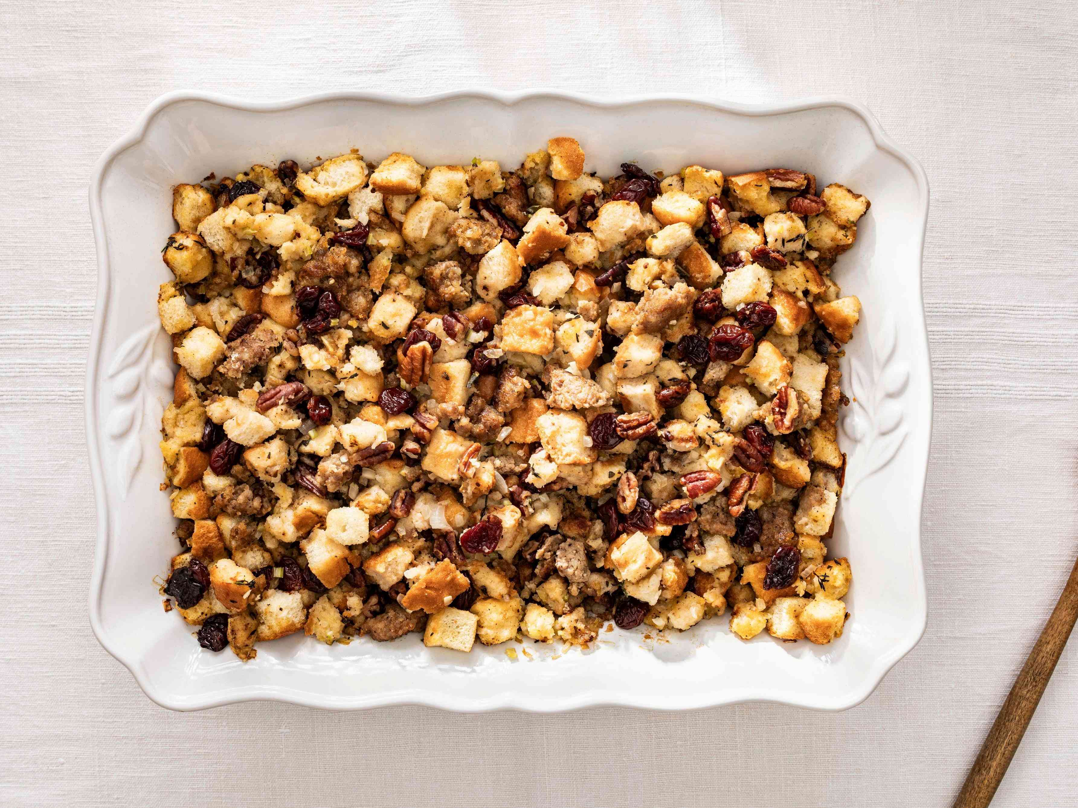 Bread Stuffing with sausage, dried cherries, and pecans in a white serving dish