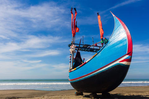 A painted moon-shaped fishing boat on Cox’s Bazar beach
