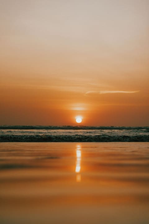 The setting sun reflected on the wet sand at Kuakata