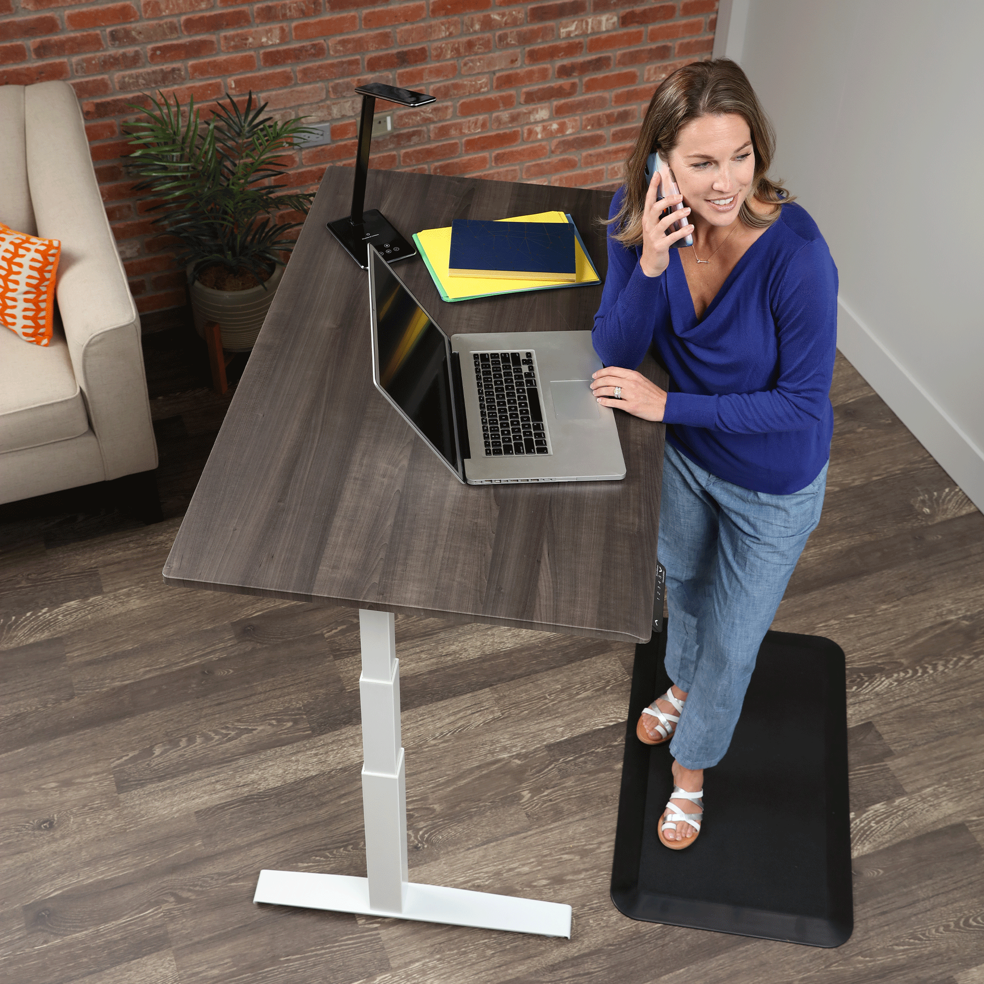 Woman in blue working from home on a SmartMoves Adjustable Height Desk