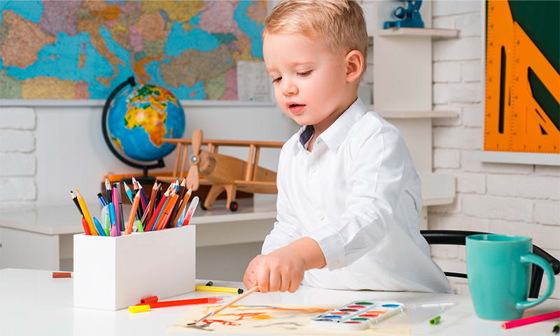 Kid doing art on an activity table