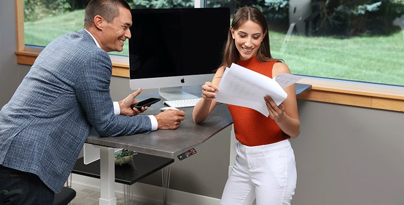 Man and Woman Standing at SmartMoves Adjustable Height Desk Together